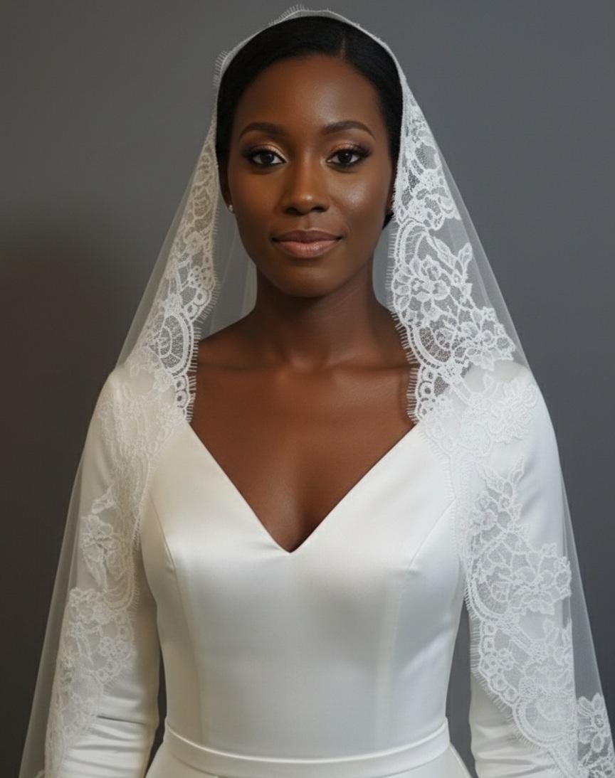 May include: A bride in a white satin wedding dress with a V-neck and long sleeves. The dress is complemented by a delicate lace veil. The veil and sleeves have detailed lace. The background is a plain grey.